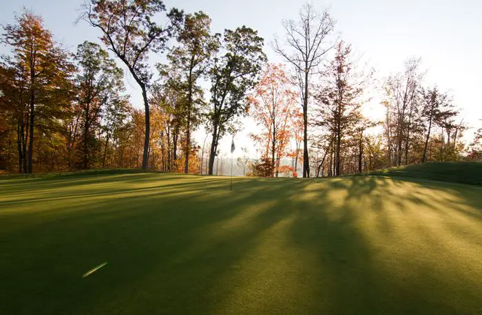 Image Twin Lakes Golf Club golf grounds with sun peeking through the pine trees