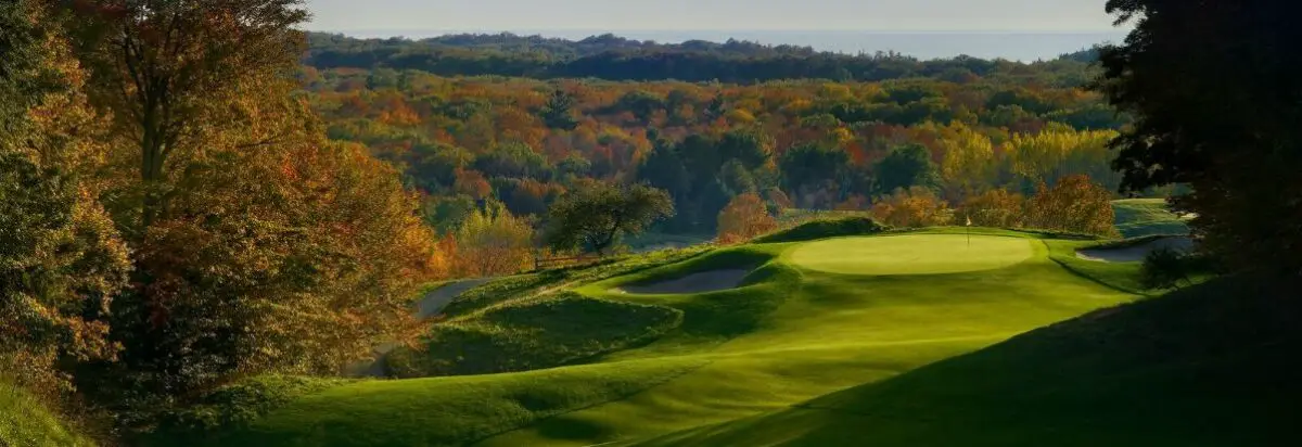 view of the fairways at Crystal Downs Country Club with the beautiful autumnal trees in the background