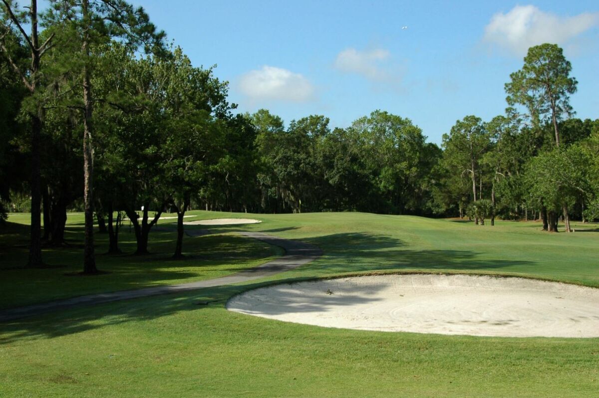 view of the greens with a bunker at Forest Course in Eagles Golf Club 