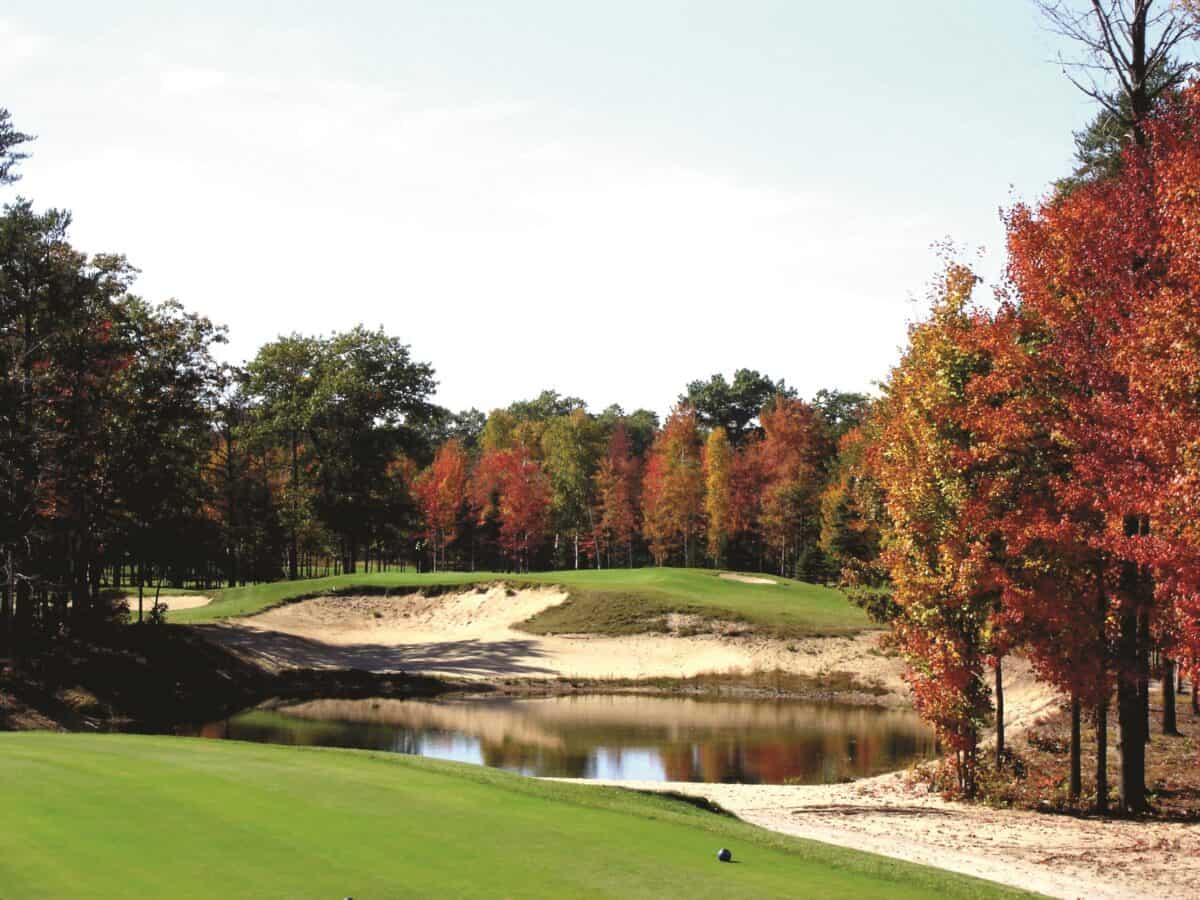 view of a hole at Lakewood Shores Resort with hazards, waterbody and bunker surrounded by fiery autumnal trees