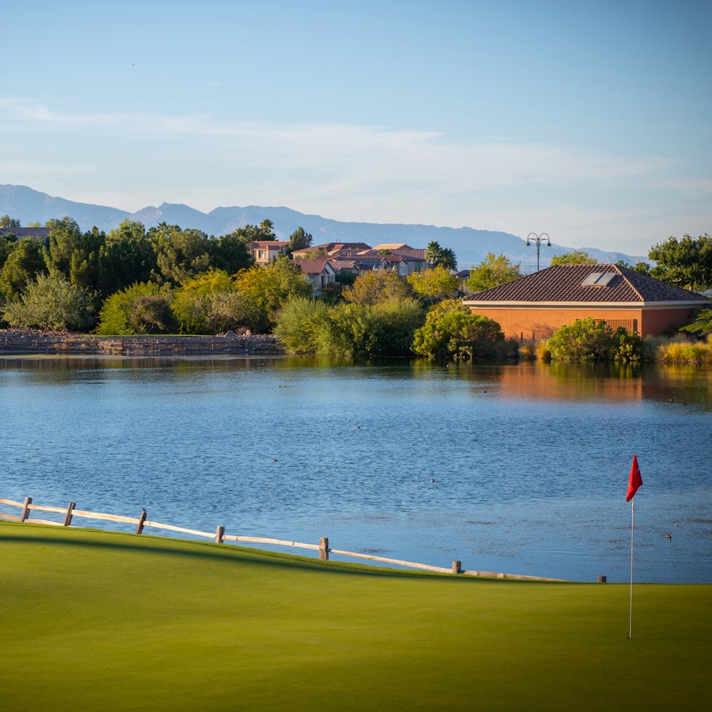 view of the greens at the Rio Secco Golf Club with the lake and mountain as the backdrop